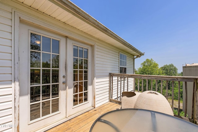 view of wooden balcony with outdoor dining area, a wooden deck, and french doors
