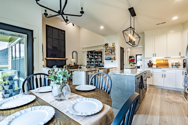dining area featuring a chandelier, light wood finished floors, and recessed lighting