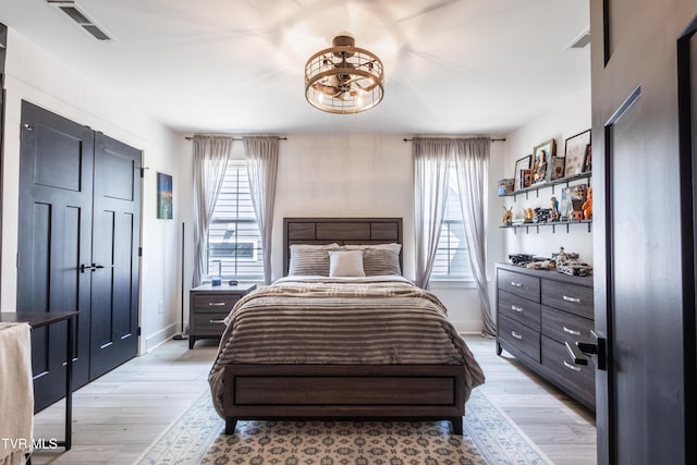 bedroom featuring light wood finished floors and baseboards
