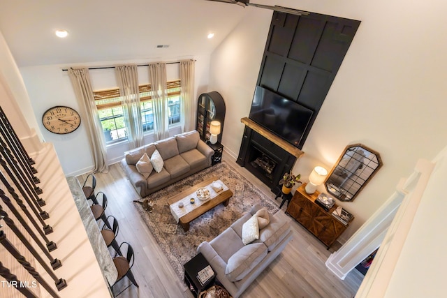 living room with wood finished floors, baseboards, recessed lighting, and a fireplace
