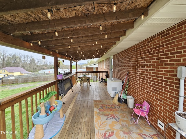 wooden terrace featuring fence and a yard
