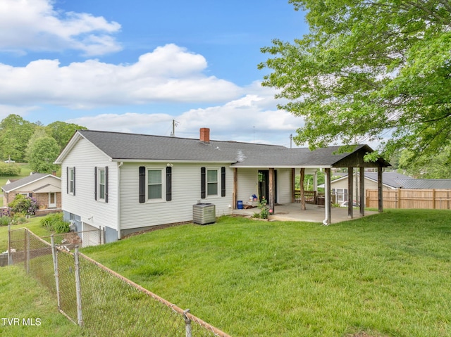 rear view of property with a fenced backyard, a patio area, a yard, and a chimney