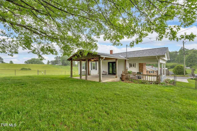 back of house with a yard, a patio, a chimney, and a fenced backyard