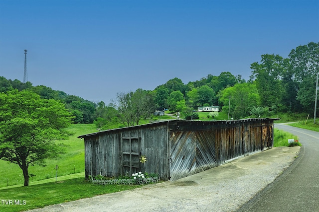view of outdoor structure featuring an outbuilding and a forest view