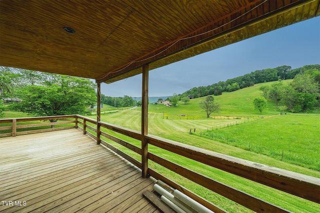 deck with a rural view and a lawn