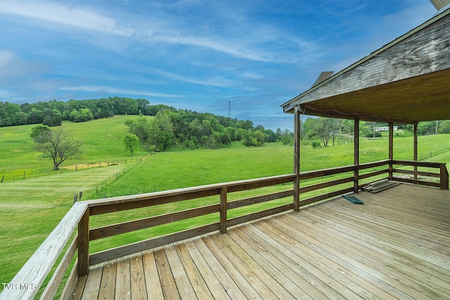 wooden terrace featuring a rural view and a lawn