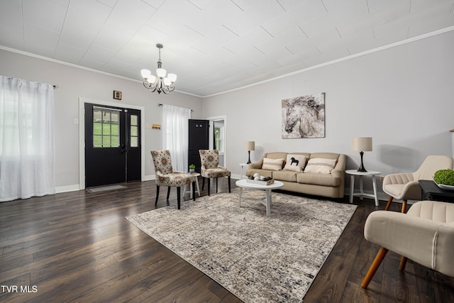 living room featuring crown molding, dark wood-type flooring, and a notable chandelier