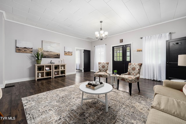 living room with baseboards, a notable chandelier, crown molding, and wood finished floors