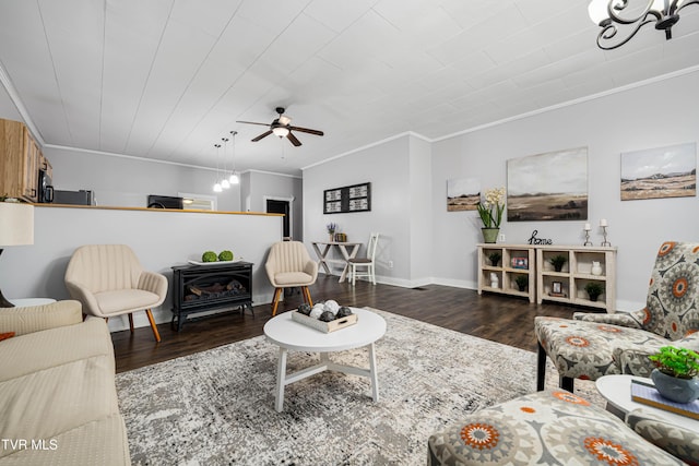 living area with ceiling fan, wood finished floors, baseboards, and ornamental molding