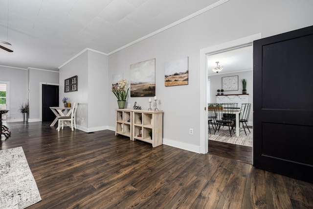 living area with baseboards, wood finished floors, a ceiling fan, and ornamental molding