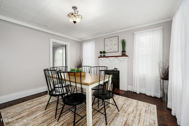 dining area with baseboards, ornamental molding, and wood finished floors