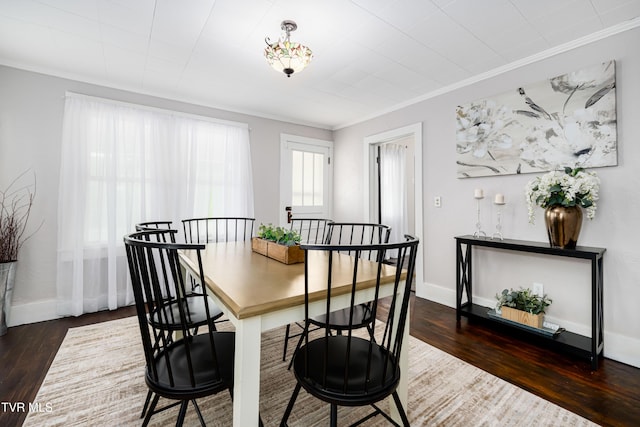 dining space featuring baseboards, ornamental molding, and wood finished floors