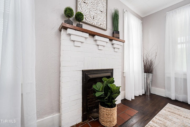 interior details with baseboards, a brick fireplace, ornamental molding, and wood finished floors