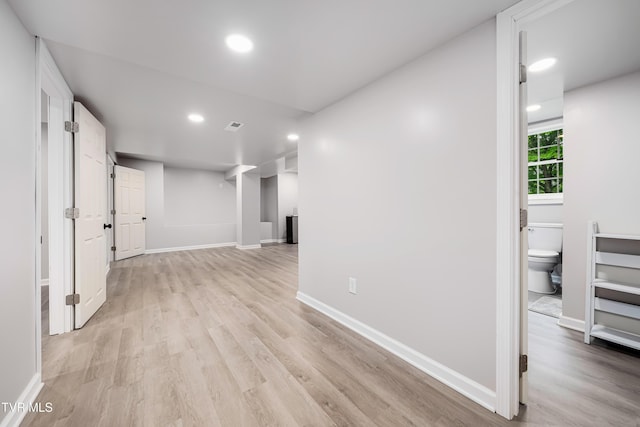 basement featuring light wood-type flooring, visible vents, baseboards, and recessed lighting