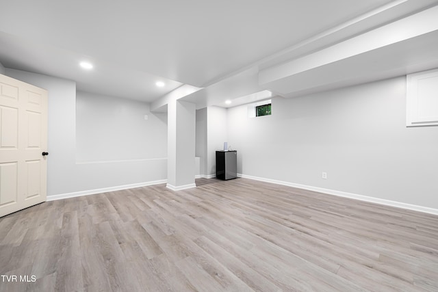 basement featuring baseboards, recessed lighting, and light wood-type flooring