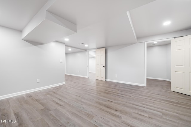 finished below grade area featuring baseboards, recessed lighting, and wood finished floors