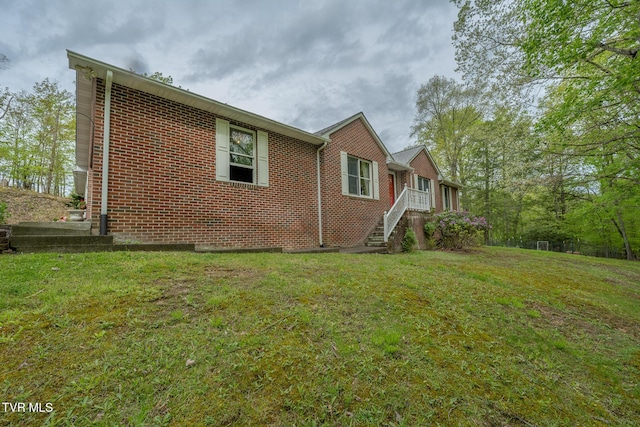 view of property exterior with a yard and brick siding