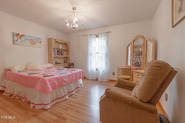 bedroom featuring light wood finished floors, baseboards, and a notable chandelier