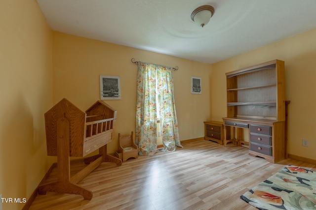 unfurnished bedroom with baseboards and light wood-style flooring