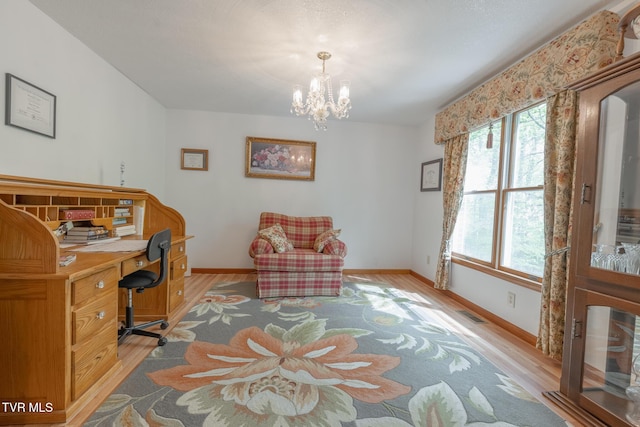 office space with baseboards, a chandelier, and light wood-type flooring
