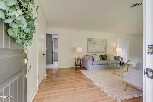 541 Vance Dr, Bristol, TN 37620 - living area featuring light wood-style flooring, a textured ceiling, baseboards, and crown molding