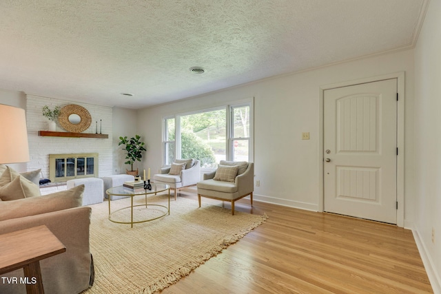 541 Vance Dr, Bristol, TN 37620 - living room with light wood-style flooring, a textured ceiling, baseboards, and a brick fireplace