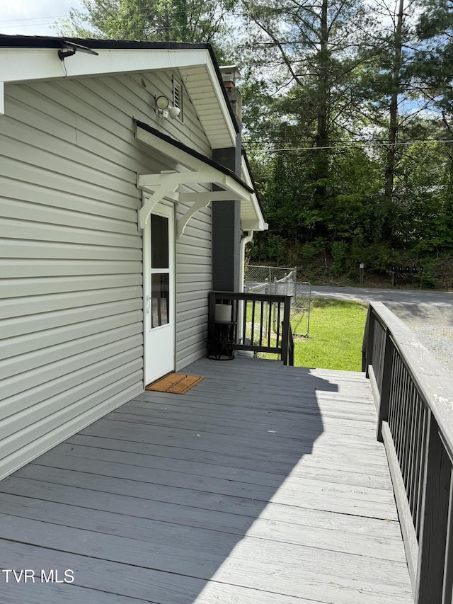 wooden terrace featuring a lawn