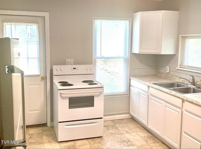 kitchen featuring a sink, white cabinetry, baseboards, electric stove, and light countertops