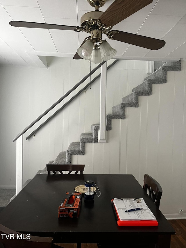 dining space with a ceiling fan and stairs
