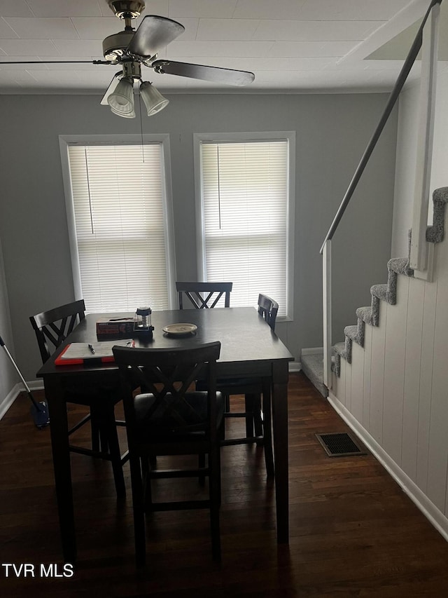 dining room with a ceiling fan, baseboards, visible vents, dark wood-type flooring, and stairway