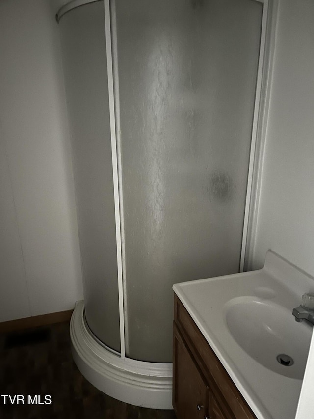 full bath with a stall shower and vanity