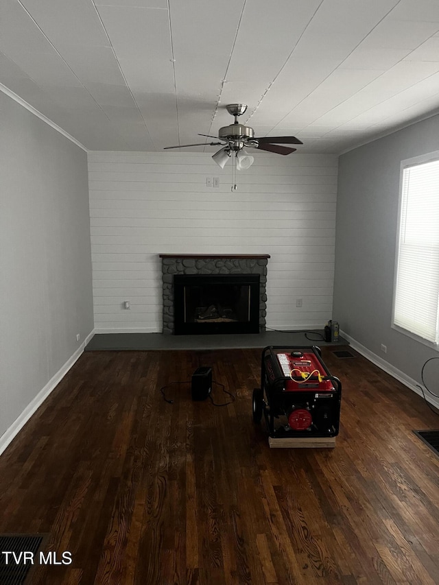 unfurnished living room with baseboards, a fireplace, ceiling fan, and wood finished floors