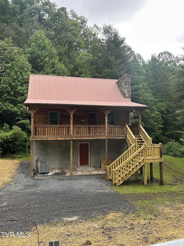 4406 Lawson Hollow Rd, Coeburn, VA 24230 - view of front of property with central AC, a chimney, stairs, metal roof, and a view of trees
