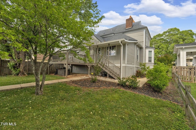 view of side of property featuring a lawn, stairs, a chimney, and fence private yard