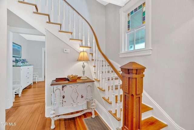 staircase with baseboards, hardwood / wood-style floors, and visible vents