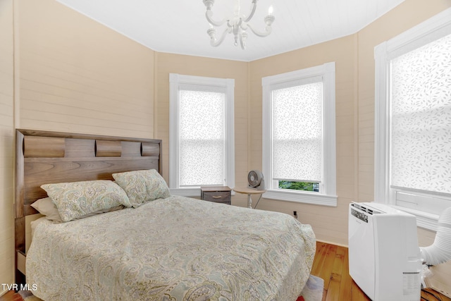 bedroom featuring wood finished floors and a notable chandelier