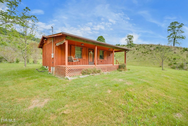 view of front facade with a porch, a front lawn, and board and batten siding