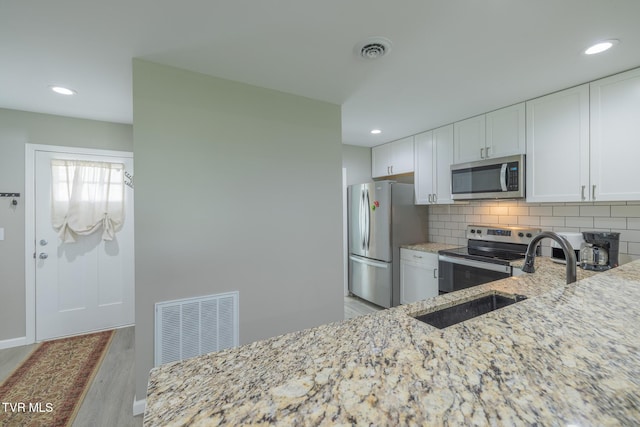 116 Weeping Willow Dr Unit 116, Abingdon, VA 24210 - kitchen with stainless steel appliances, light stone countertops, light wood-type flooring, a sink, and white cabinets