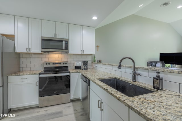 116 Weeping Willow Dr Unit 116, Abingdon, VA 24210 - kitchen with stainless steel appliances, a sink, vaulted ceiling, light wood finished floors, and white cabinetry