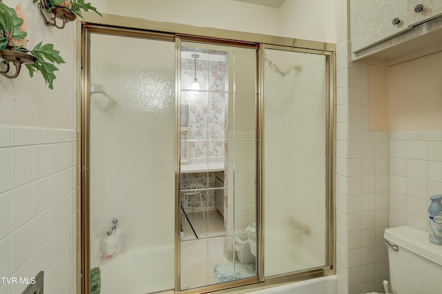 600 Valley Ave, Erwin, TN 37650 - full bath featuring toilet, tile walls, wainscoting, and combined bath / shower with glass door