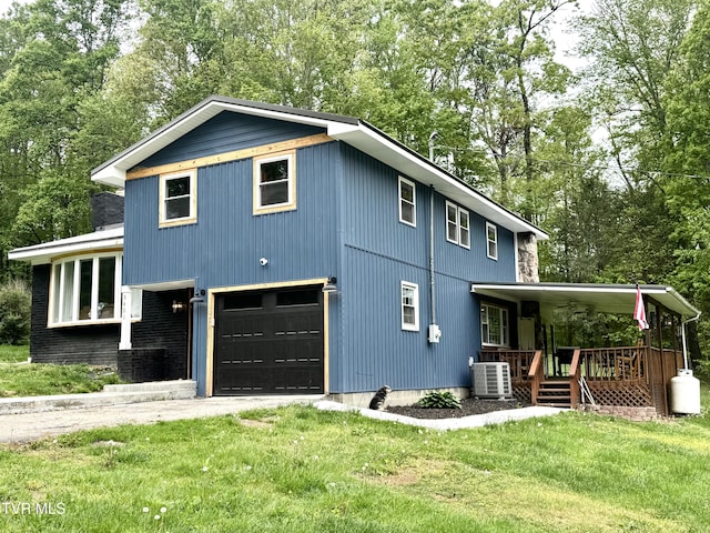 3401 Fairfax Rd, Coeburn, VA 24230 - view of front of home featuring covered porch, a front yard, a garage, view of wooded area, and central air condition unit