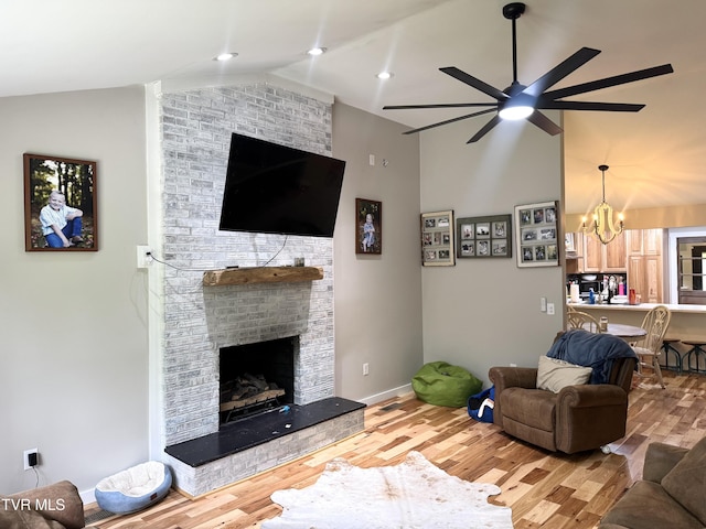 3401 Fairfax Rd, Coeburn, VA 24230 - living room featuring a ceiling fan, wood finished floors, a chandelier, a brick fireplace, and high vaulted ceiling