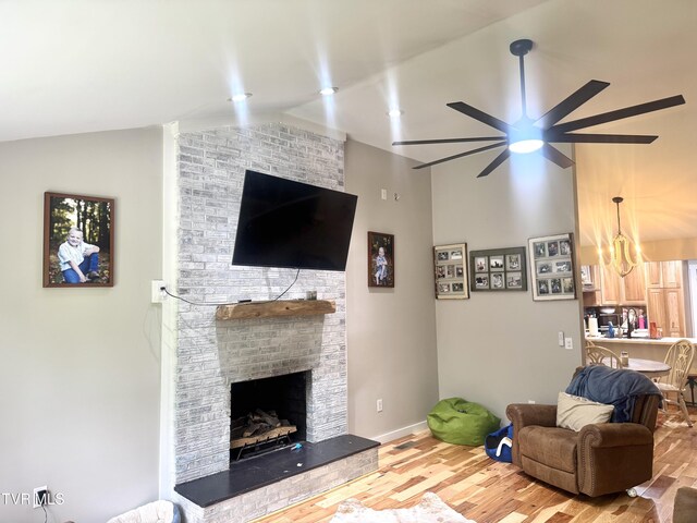 3401 Fairfax Rd, Coeburn, VA 24230 - living area with vaulted ceiling, ceiling fan, a fireplace, wood finished floors, and a chandelier