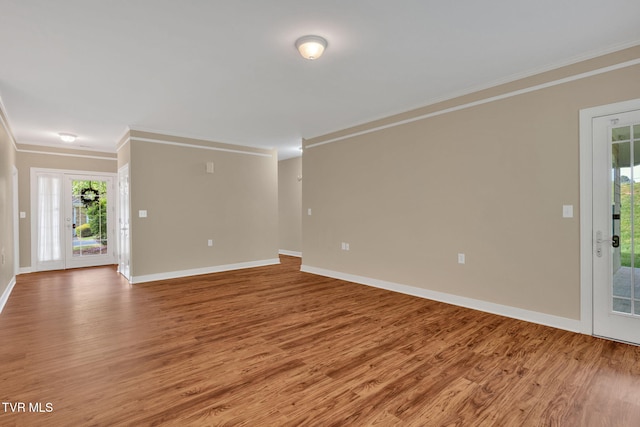 unfurnished living room with light wood-style floors, plenty of natural light, baseboards, and ornamental molding