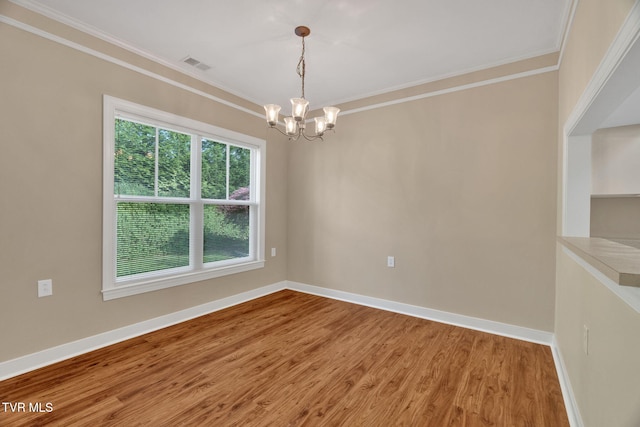 unfurnished room featuring an inviting chandelier, visible vents, and crown molding