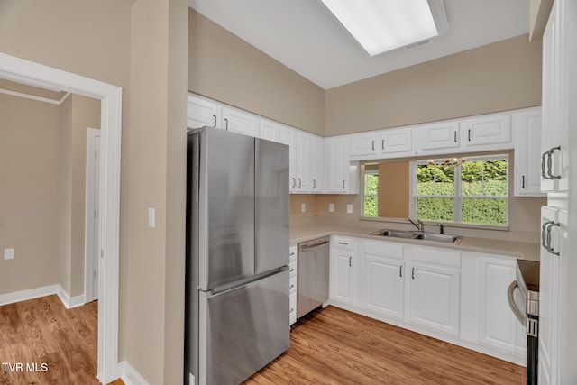 kitchen featuring a sink, stainless steel appliances, light countertops, and light wood-type flooring