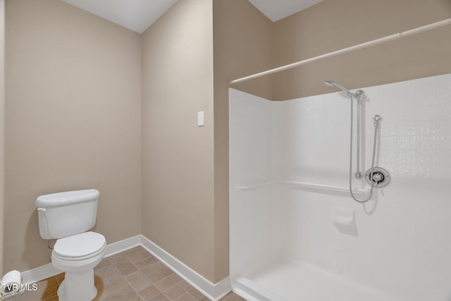 full bathroom with walk in shower, toilet, and baseboards