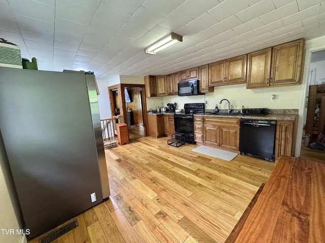 7311 Rocky Fork Rd, Wise, VA 24293 - kitchen featuring a sink, brown cabinetry, black appliances, visible vents, and light wood finished floors