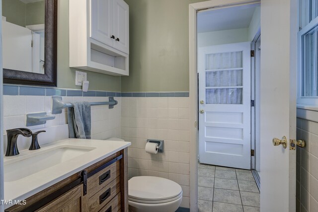 2405 Larkspur Dr, Johnson City, TN 37604 - half bathroom with tile walls, toilet, vanity, tile patterned floors, and wainscoting