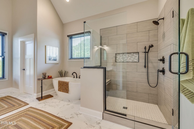 full bath with a shower stall, a freestanding bath, baseboards, vaulted ceiling, and marble finish flooring